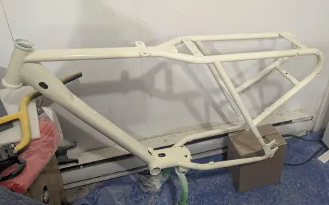 Nyligen sprayad cykelram i en ljusgul nyans, redo för nya äventyr.
