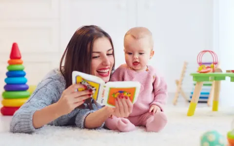 Mama czyta książeczkę kolorową, a jej 2 letnie dziecko z zaciekawieniem słucha.