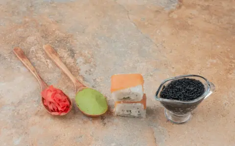 Na łyżkach imbir marynowany właściwości, zielone wasabi, sushi z łososiem i czarny kawior.