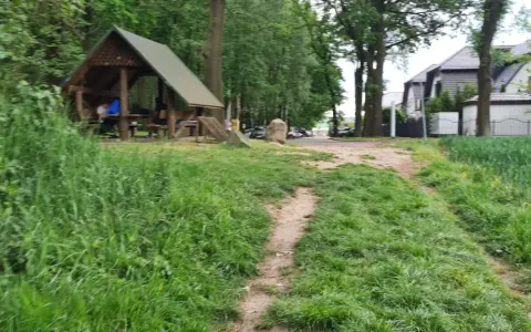 Ścieżka wśród zieleni prowadzi do altany, idealnej na odpoczynek po przejażdżce po trasach rowerowych Ruda Śląska.