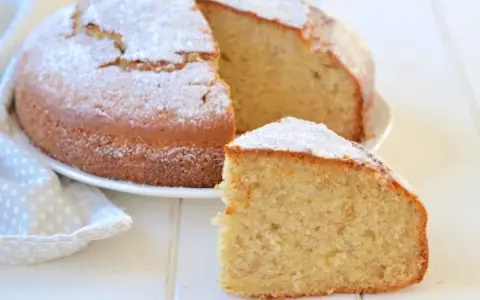 Una soffice torta di banane, spolverata di zucchero a velo, con una fetta tagliata per gustarla.