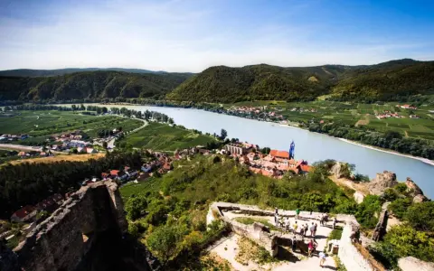 Widok na malowniczą dolinę Wachau z ruinami zamku, rzeką Dunaj i winnicami.