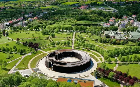 Widok z lotu ptaka na park i tężnię solankową w Busku-Zdroju. W oddali widać zabudowania i zielone wzgórza. Sanatoria w Busku-Zdroju oferują relaks i zdrowie.