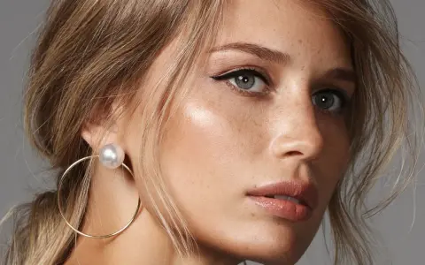 Delikatny makijaż na wesele dla blondynek: subtelne podkreślenie oczu i ust, złote kolczyki.