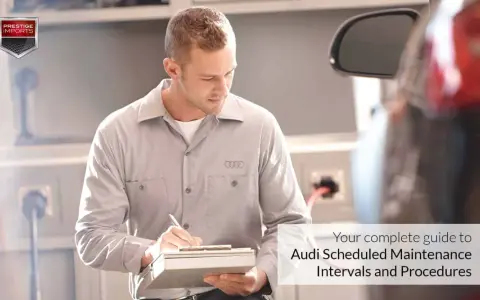 Mechanik z logo Audi na koszulce notuje szczegóły w dokumencie. Twój kompletny przewodnik po **Audi plan serwisowy**.