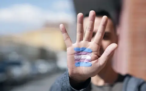 Dłoń z namalowaną flagą osób transpłciowych. To symbol wsparcia dla tych, którzy identyfikują się jako kto to transwestyta.