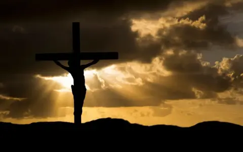 Silhouette of Jesus on the cross against a dramatic sky. His sacrifice shows Jesus died for our sins, offering hope.