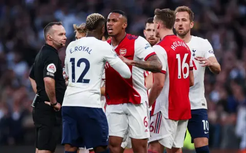 Piłkarze Arsenalu i Tottenhamu w gorącej dyskusji z sędzią. To właśnie co to są derby w piłce nożnej – mecze pełne emocji i napięcia.