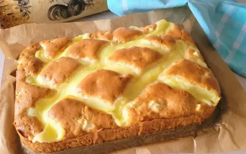 Puszyste ciasto jogurtowe z kremowym nadzieniem, upieczone na papierze do pieczenia.