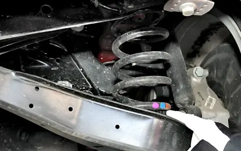 Pęknięta sprężyna tył samochodu, widoczna na zdjęciu, może powodować nieprzyjemne wrażenia podczas jazdy.