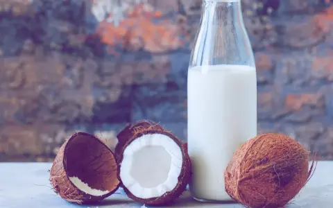 Frische Kokosnüsse und eine Flasche Kokosmilch, bereit zum Kokosmilch einfrieren.