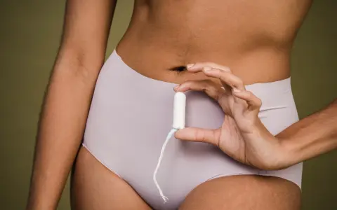 Mano sostiene un tampón. ¿Buscas cómo adelantar la regla?