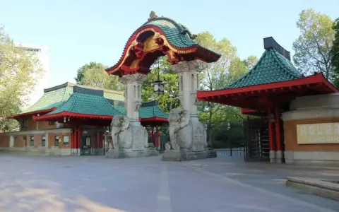 Eingang zum zoologischer garten mit asiatischer Architektur, Elefantenstatuen und grünen Dächern.