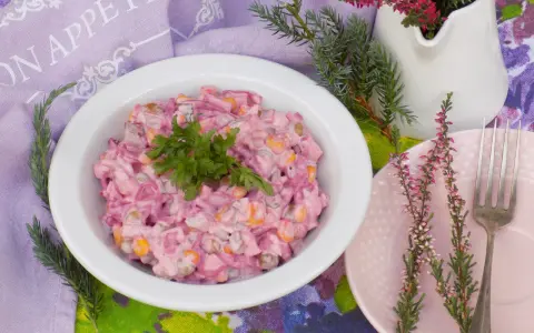 Pyszna sałatka z burakiem i jajkiem i ogórkiem kiszonym, udekorowana natką pietruszki. Idealna na każdą okazję.