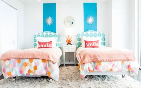 Dos camas gemelas en habitación pequeña, con cabeceros estampados y colchas naranjas. ¡Una solución genial para como poner dos camas en una habitacion pequeña!