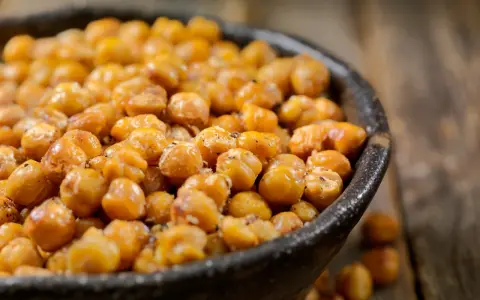 Ciotola piena di ceci tostati, croccanti e dorati. Attenzione, i ceci fanno ingrassare se mangiati in grandi quantità!