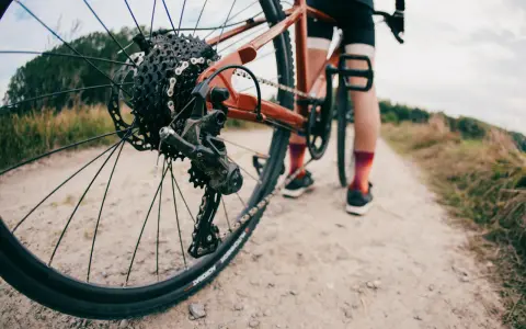 Rowerzysta na szutrowej drodze. Długość korby a wzrost to klucz do komfortowej jazdy.