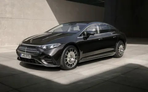 Schwarzer Mercedes-Benz EQS mit Facelift-Design, elegant vor Betonwand.