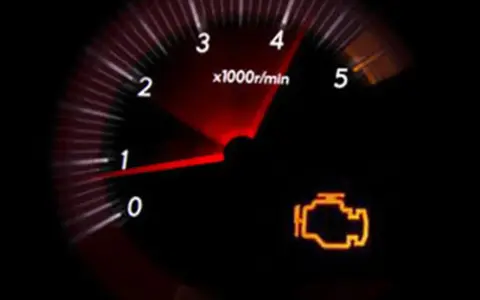 Cruscotto con spia motore accesa, indicando possibili perdita potenza motore diesel cause. Il contagiri mostra bassi giri.