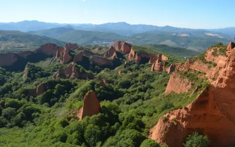 Paisaje de Las Médulas, León. Impresionantes formaciones rojizas y vegetación exuberante, ideal para rutas senderismo León.