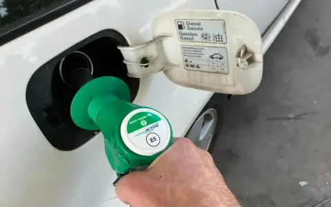 Tankowanie auta. Pistolet z zieloną końcówką, oznaczony jako "euro super Pb E5", jest wkładany do wlewu paliwa. Na klapce wlewu widnieje napis "Diesel".