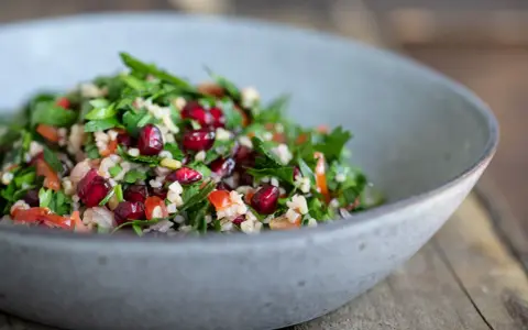 Frischer Tabouleh-Salat mit Granatapfelkernen, Petersilie und Bulgur. Ein köstliches tabouleh rezept für den Sommer.