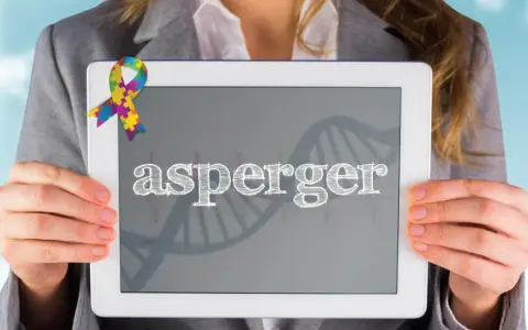 Kolorowa wstążka symbolizuje świadomość autyzmu. Na tablecie widnieje napis "asperger", a w tle grafika DNA, nawiązująca do objawów Aspergera.
