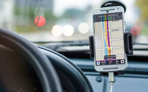 Uchwyt na telefon w samochodzie z nawigacją. Pokazuje trasę w Amsterdamie, jak zamontować uchwyt na telefon w samochodzie.