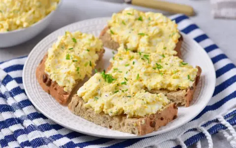 Pyszna pasta z jajek na chlebie, posypana szczypiorkiem i pieprzem. Idealna na szybkie śniadanie lub przekąskę.