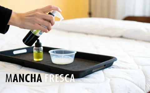 Persona rocía líquido de una botella sobre una bandeja con un recipiente pequeño. Aprende como desinfectar un colchon.