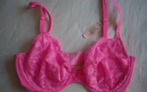 Reggiseno rosa acceso con pizzo floreale, spalline regolabili e un piccolo fiocco al centro. Taglia coppa DD.