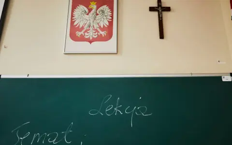 Na ścianie wisi godło Polski i krzyż. Na tablicy napisano "Temat: Lekcja". Czy religia wlicza się do średniej?