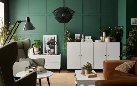Zieleń ścian idealnie komponuje się z białymi meblami, tworząc eleganckie i nowoczesne wnętrze.