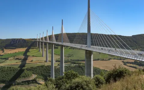 El viaducto de Millau, una maravilla de la ingeniería, se alza majestuoso sobre un valle verde. Su construcción desafía la gravedad.