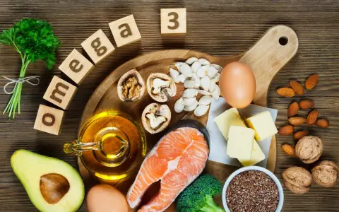 Assortiment d'aliments riches en oméga 3 : saumon, noix, avocat, œufs, huile, graines de lin, amandes, brocolis et beurre.