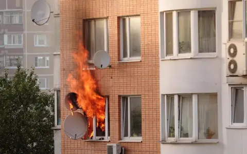 Flammen schlagen aus einem Fenster eines Mehrfamilienhauses. Ein trauriger Anblick, besonders wenn man bedenkt, dass es sich um einen wohnungsbrand ohne hausratversicherung handelt.