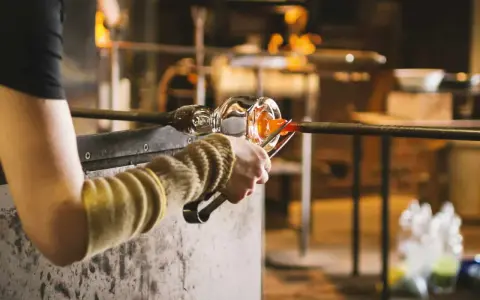 Souffleur de verre travaillant le verre en fusion, un métier qui mérite un bon salaire.