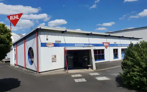 Gebäude von Ruhl Autoteile mit rotem Schild und blauem Schriftzug "AUTOTEILE und mehr...".