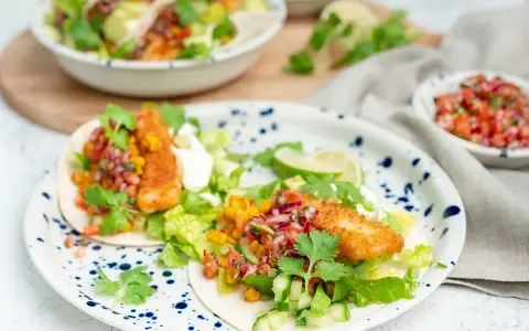 Två läckra fish tacos med krispig fisk, färsk salsa, majs och grönsaker. En festlig måltid!