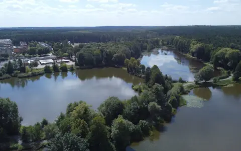 Malownicze jezioro Blachownia otoczone lasem, z widocznymi budynkami i drogami.