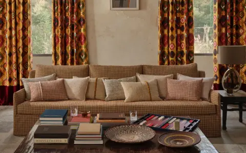 Cortinas con estampado geométrico vibrante, un sofá acogedor y cojines texturizados. Las ultimas tendencias cortinas salon se reflejan en este espacio.