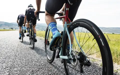 Cyclists on an endurance bike vs road bike race down a gravel road, showcasing their gear and determination.