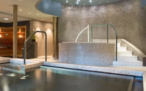 Avslappnande poolområde med bastu och trappa ner till vattnet på Lindvallen Skilodge.