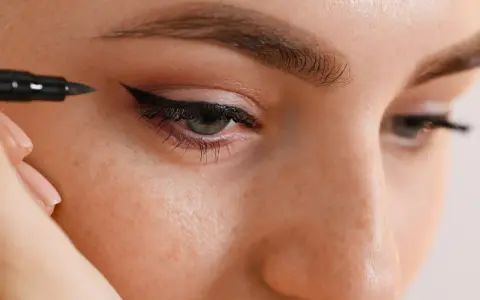 Application d'un trait d'eyeliner permanent pour un regard intense.