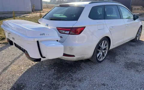 Biały box bagażowy na hak holowniczy zamontowany z tyłu białego kombi.