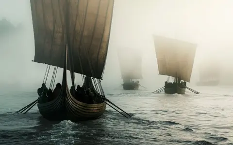 Vikingaskepp i dimma, en påminnelse om spännande fakta om vikingatiden och deras resor över havet.