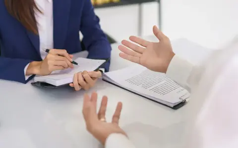 Rozmowa o zmianach w prawie pracy 2026. Kobieta w garniturze notuje, mężczyzna gestykuluje.