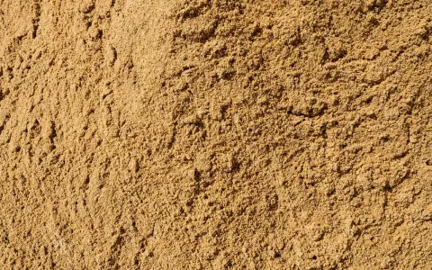 Textura de arena de miga, ideal para construcción, jardinería y filtración. Sus usos son variados y esenciales.