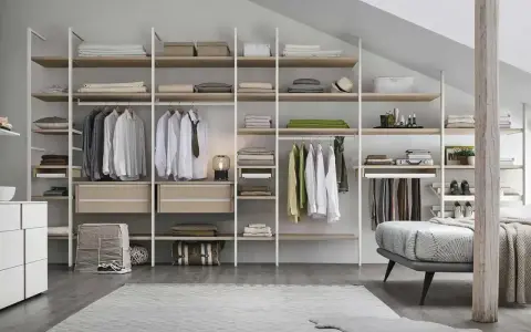 Un'idea per progettare cabina armadio: scaffali a vista con abiti appesi, cassetti e accessori.
