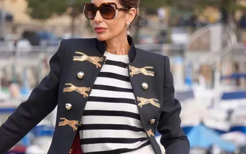 Elegancka kobieta w okularach przeciwsłonecznych i marynarce z motywem gepardów, w stylu francuskim.